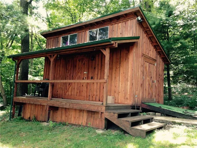 a view of a small house with a small deck and furniture