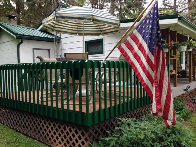 a view of a house with a small yard and deck