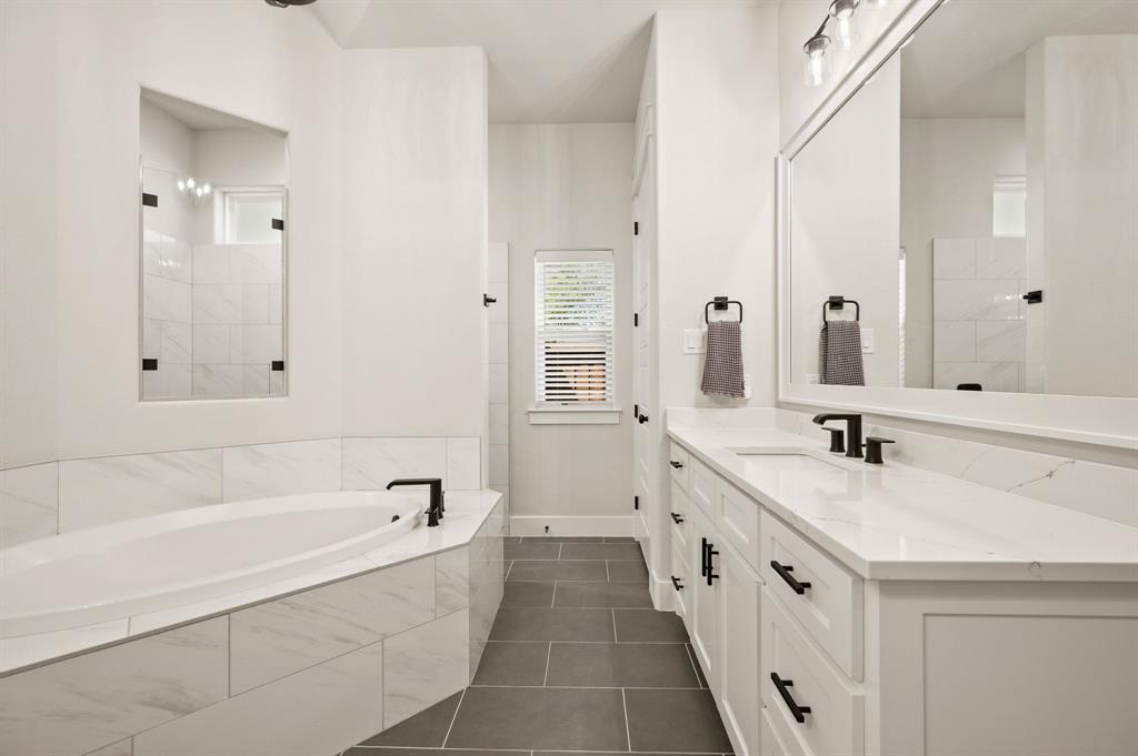 200 Clayton Crossing Springtown, TX 76082 - Photo 19 of 40 a bathroom with a granite countertop double vanity sink a mirror and a bathtub