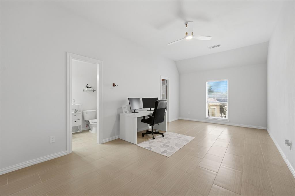3315 Ricci Lane Irving, TX 75062 - Photo 32 of 40 Spacious room featuring light-toned tile flooring, a sloped ceiling, and a ceiling fan
