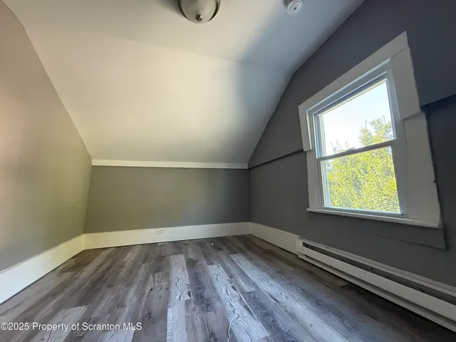 a view of a room with wooden floor and window