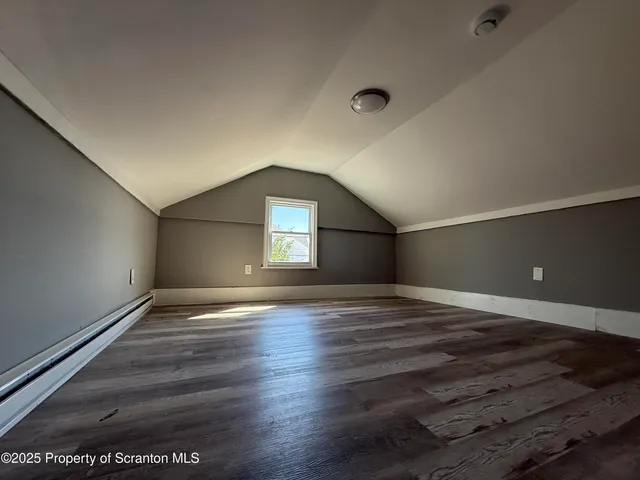 a view of empty room with window and wooden floor