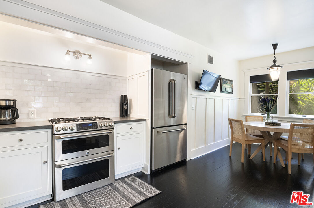1918 Pinehurst Road Los Angeles, CA 90068 - Photo 39 of 66 a kitchen with a stove a refrigerator and a dining table