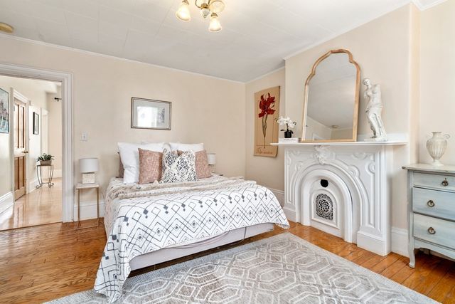 a bedroom with a bed a mirror and lamp on table