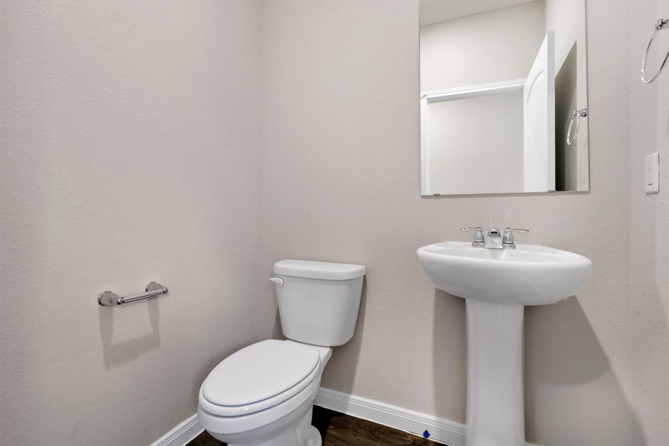 2909 Tweedy Trail Pflugerville, TX 78660 - Photo 21 of 27 A well-appointed powder room features a classic pedestal sink and toilet, set against neutral walls.