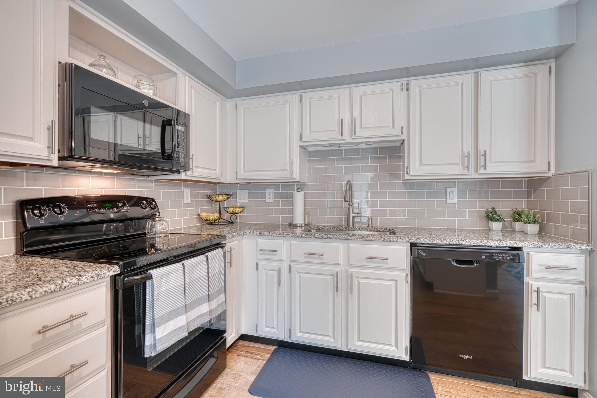 25 Ramsgate Court Halethorpe, MD 21227 - Photo 14 of 30 a kitchen with granite countertop white cabinets and stainless steel appliances