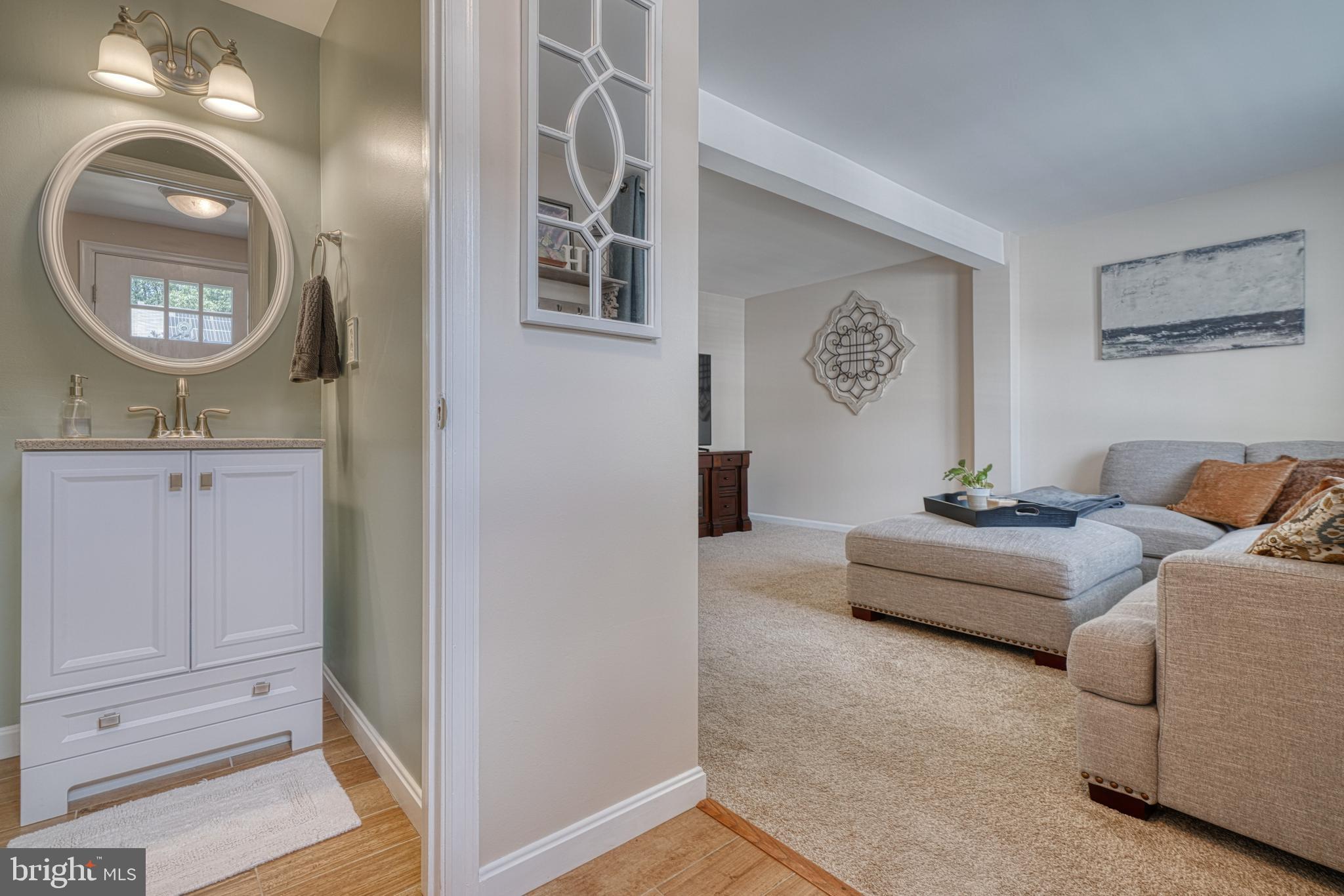 25 Ramsgate Court Halethorpe, MD 21227 - Photo 3 of 30 a living room with furniture a mirror and a wooden floor