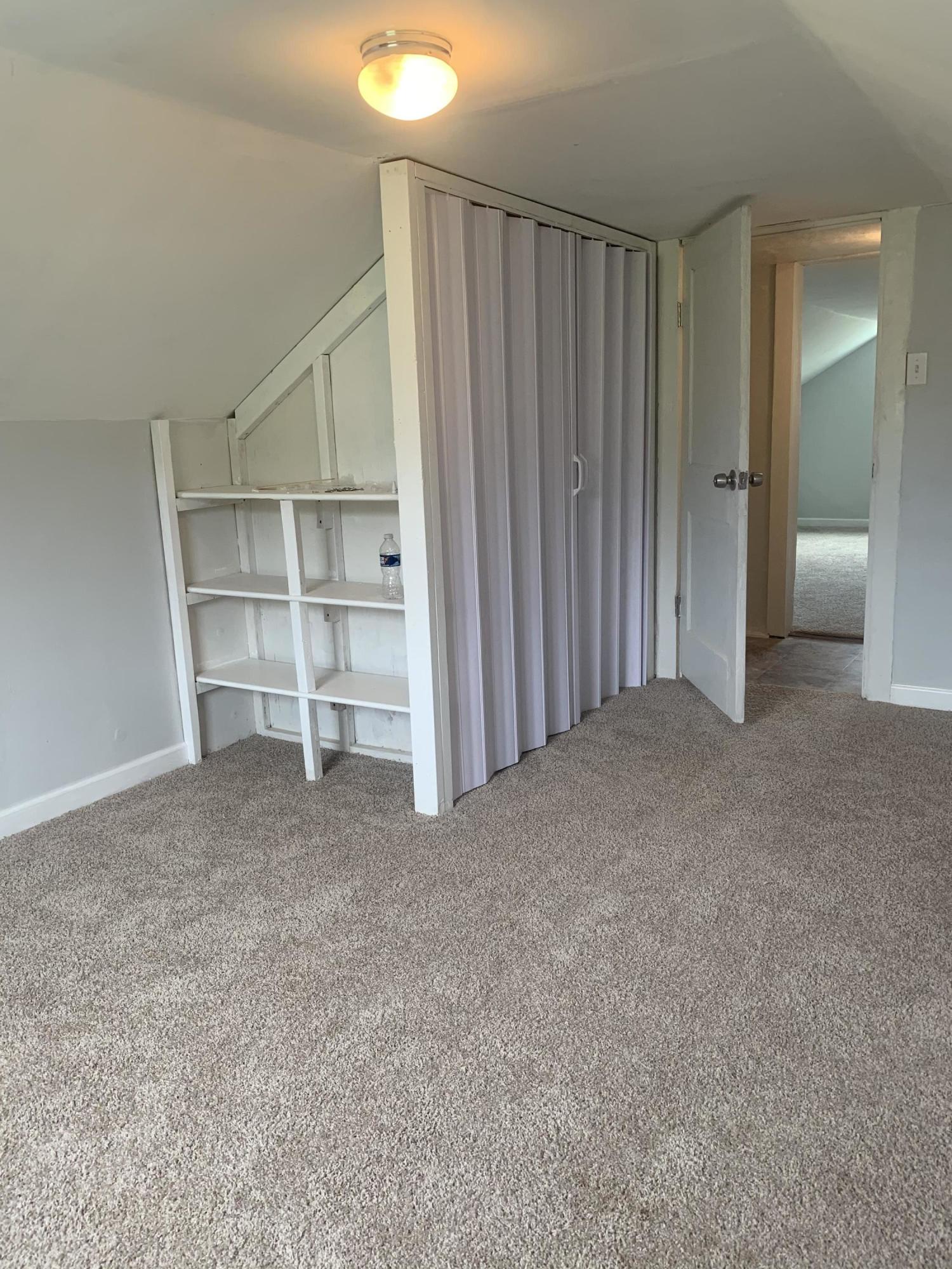 4704 Goodman Road Roanoke, VA 24014 - Photo 18 of 25 an empty room with a wooden shelves