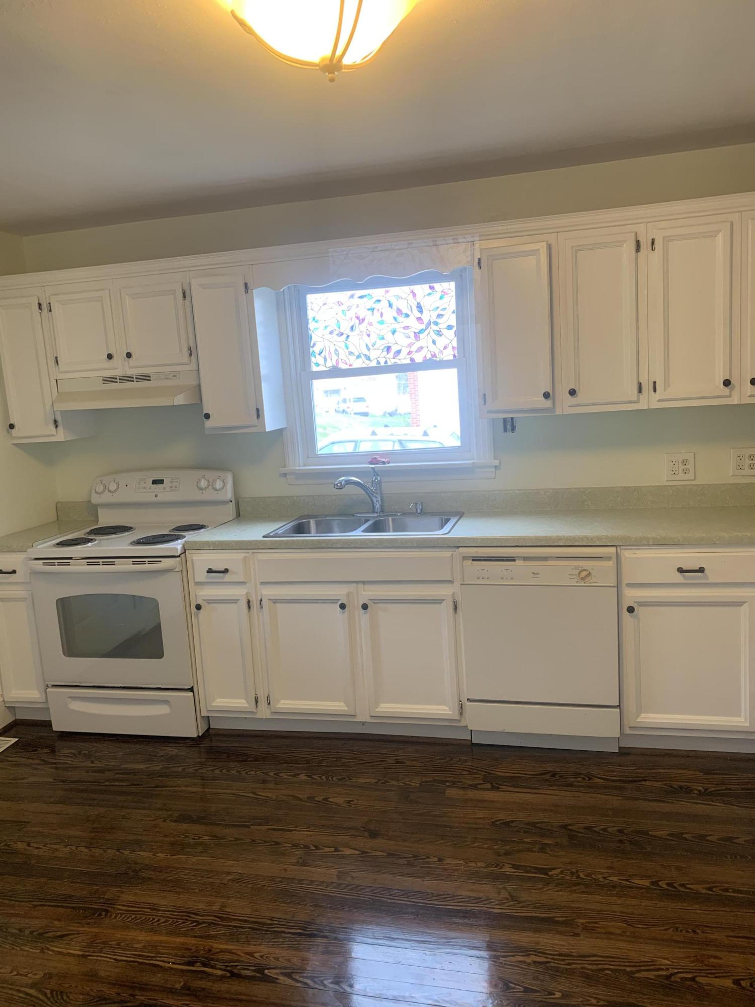 4704 Goodman Road Roanoke, VA 24014 - Photo 7 of 25 a kitchen with granite countertop white cabinets and white appliances