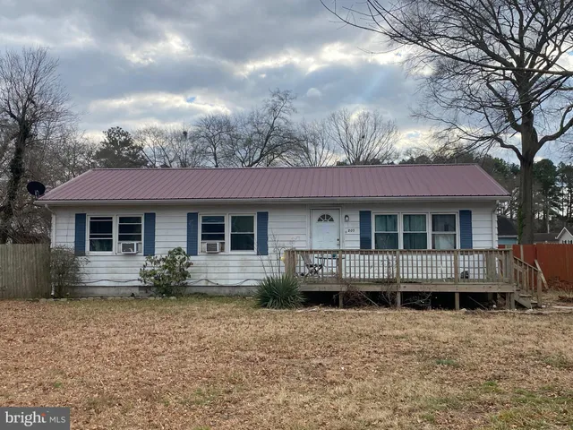 a front view of a house with yard and trees