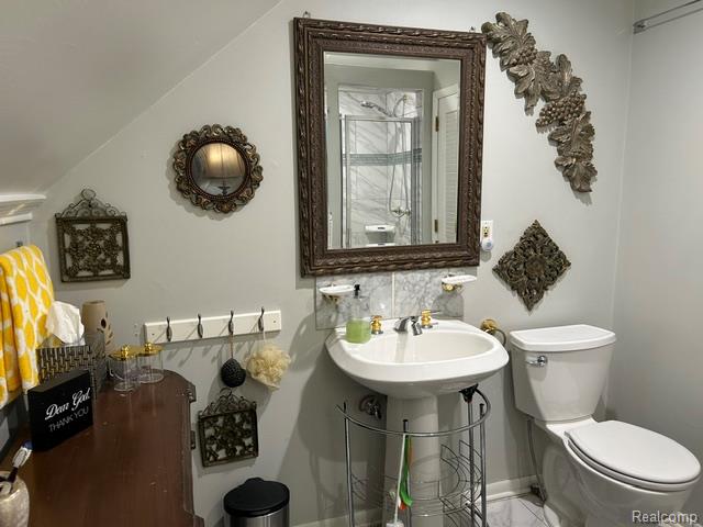89 Muir Road Grosse Pointe, MI 48236 - Photo 23 of 29 Pedestal sink with brass-finish faucet, framed mirror, and a white toilet