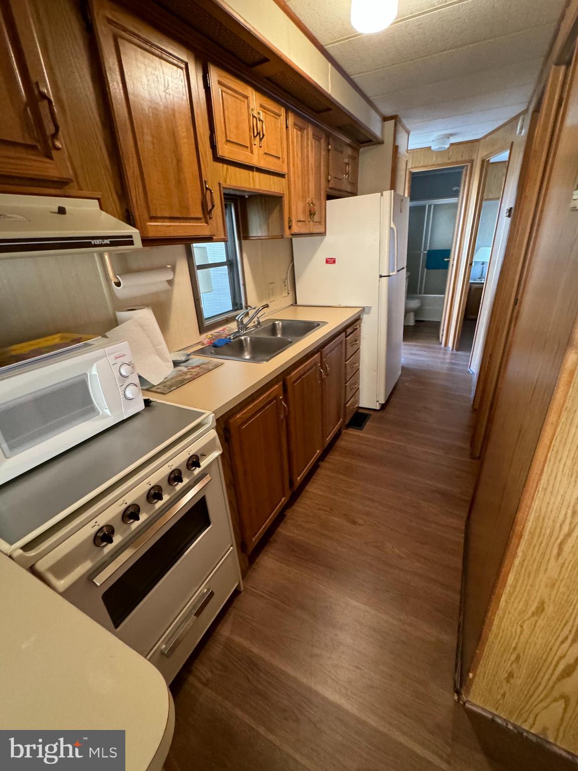 148 Ocean Oval Drive Berlin, MD 21811 - Photo 19 of 29 a kitchen with wooden cabinets and a stove top oven