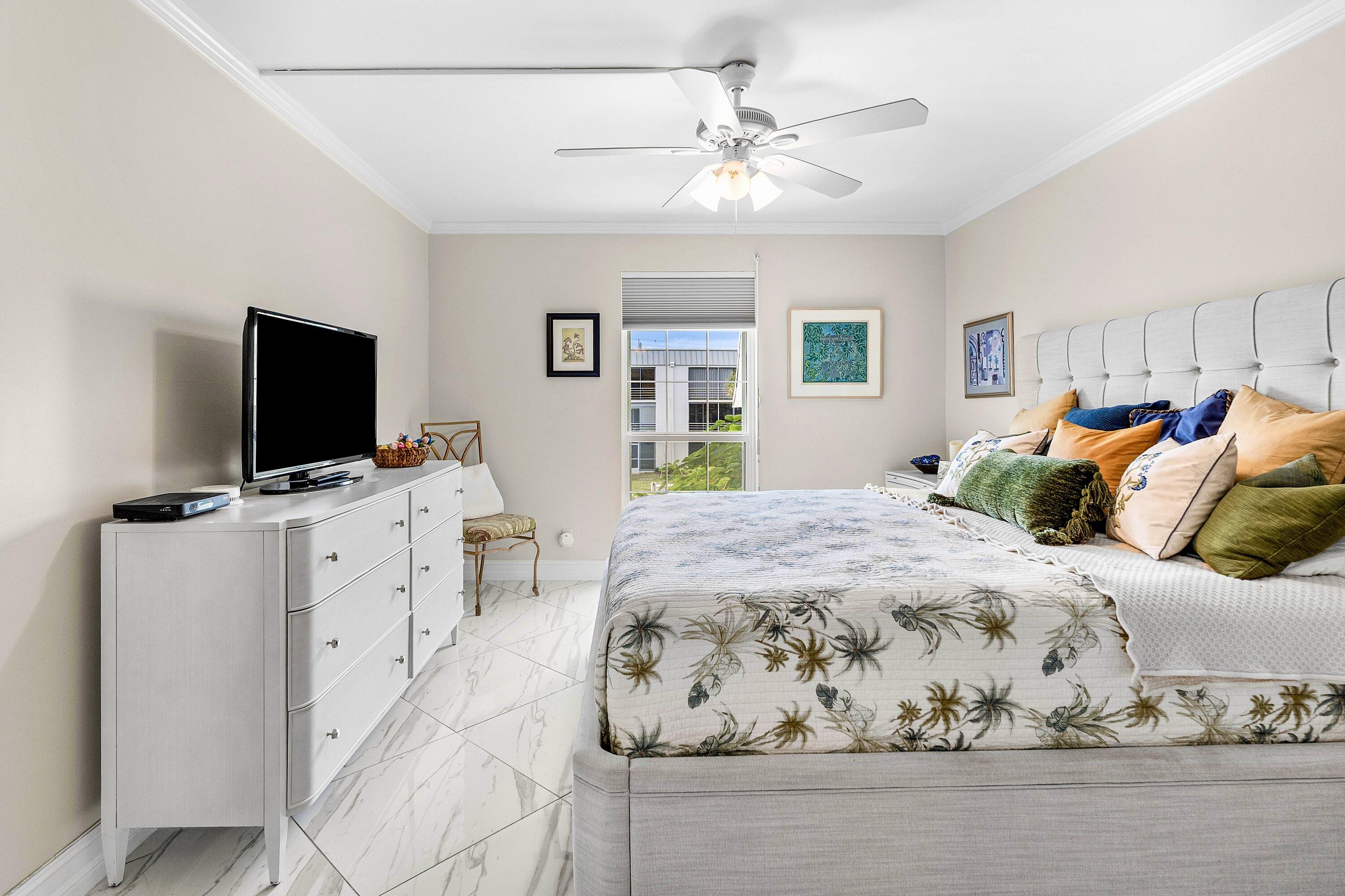 765 Jeffery Street, Unit 1203 Boca Raton, FL 33487 - Photo 17 of 31 a spacious bedroom with a bed and a flat screen tv