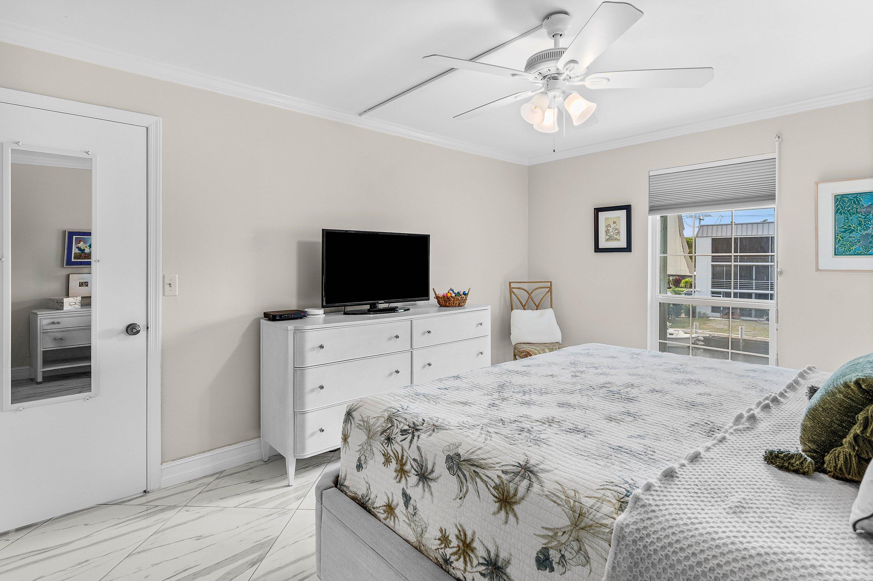 765 Jeffery Street, Unit 1203 Boca Raton, FL 33487 - Photo 18 of 31 a bedroom with a bed and a flat screen tv