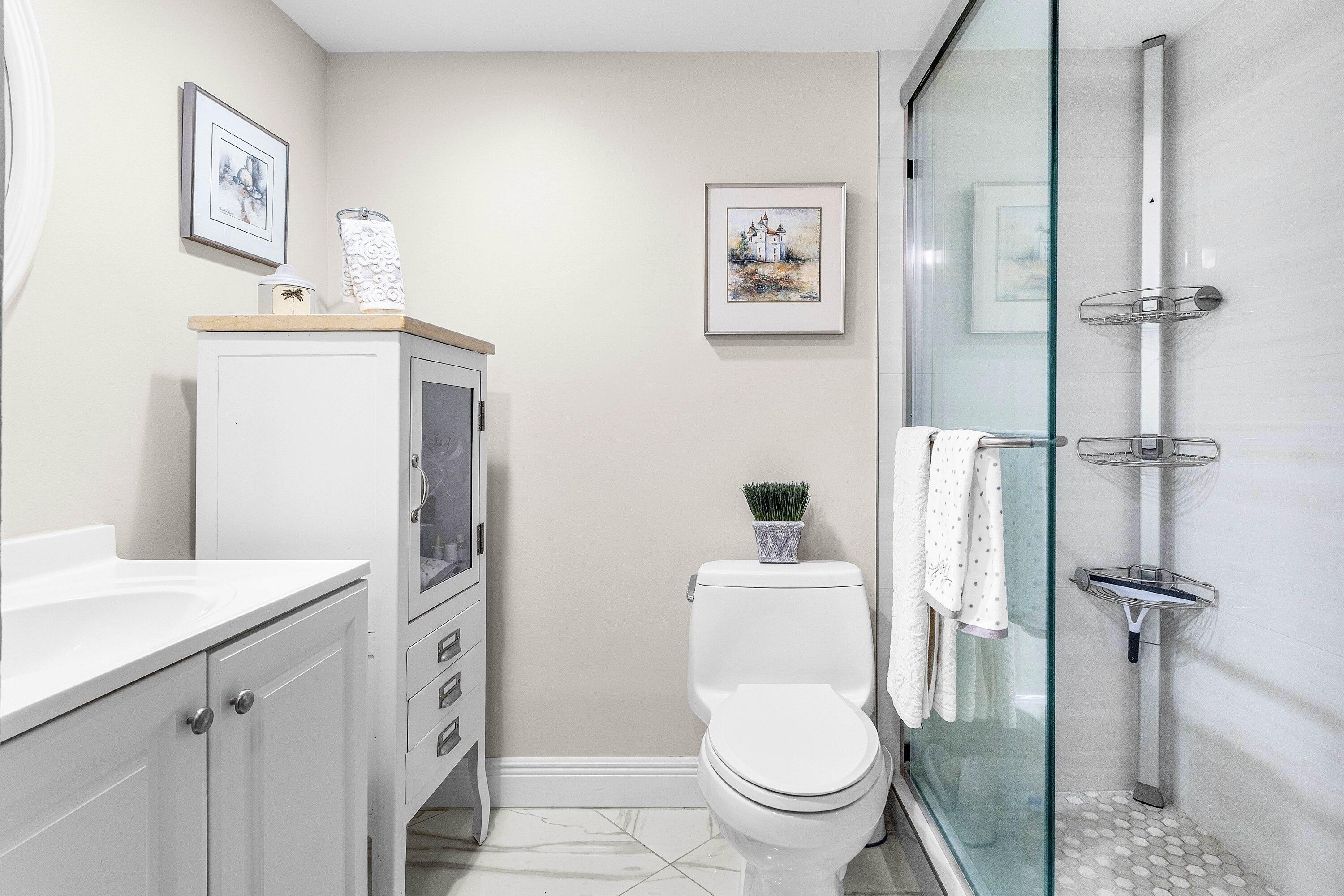 765 Jeffery Street, Unit 1203 Boca Raton, FL 33487 - Photo 20 of 31 a white toilet sitting next to a bathroom sink