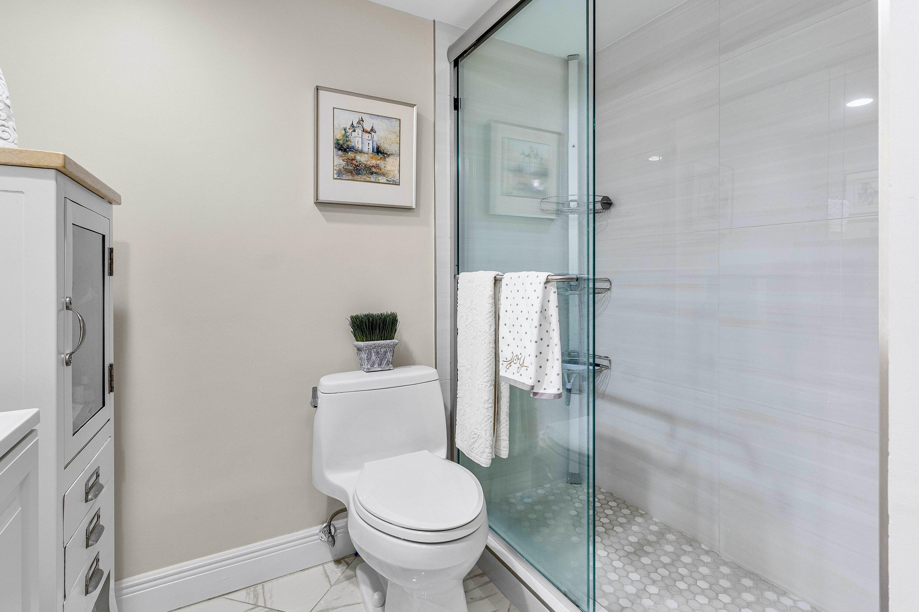 765 Jeffery Street, Unit 1203 Boca Raton, FL 33487 - Photo 21 of 31 a white toilet sitting next to a bathroom sink