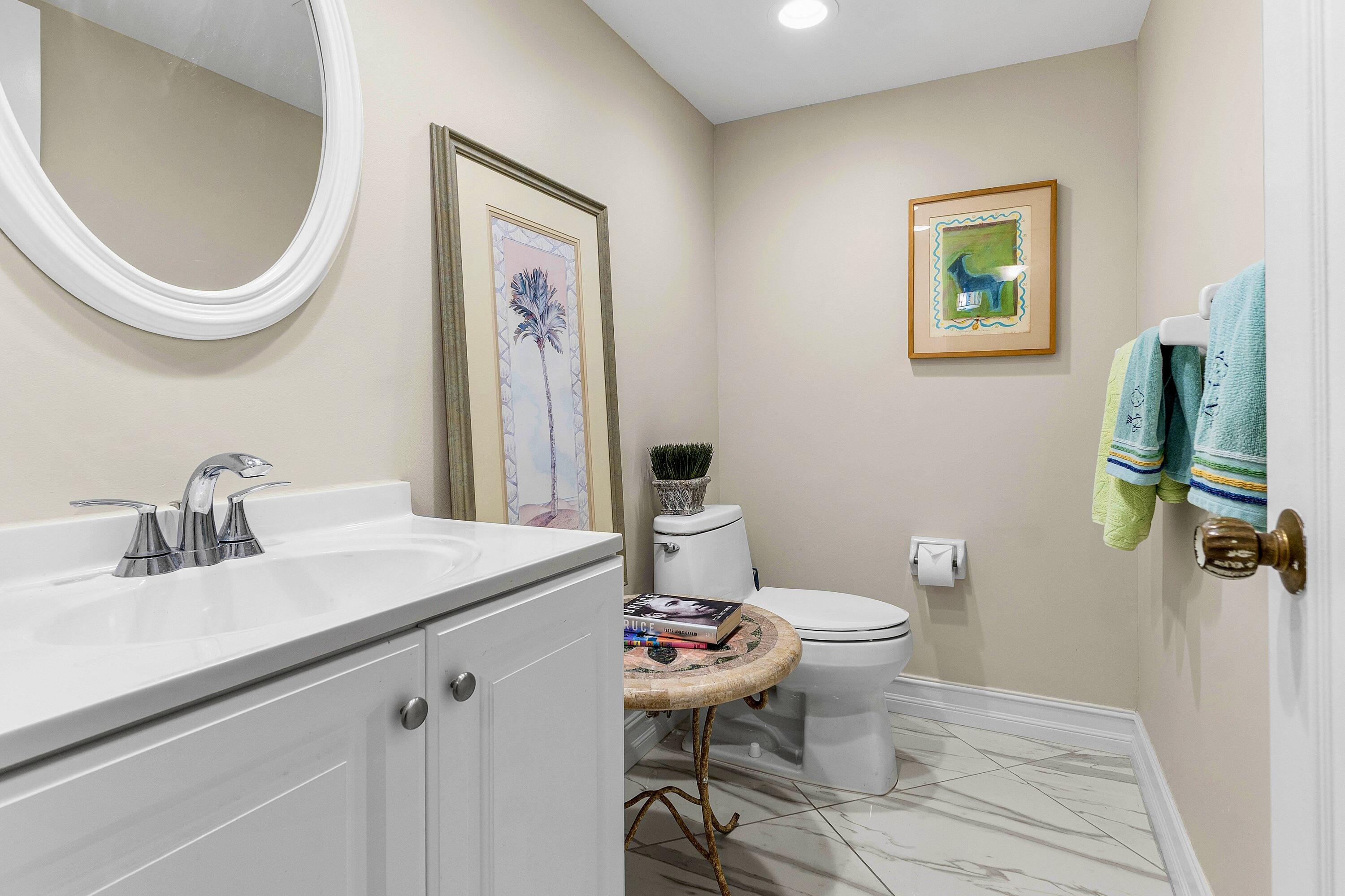 765 Jeffery Street, Unit 1203 Boca Raton, FL 33487 - Photo 23 of 31 a bathroom with a toilet a sink and a mirror