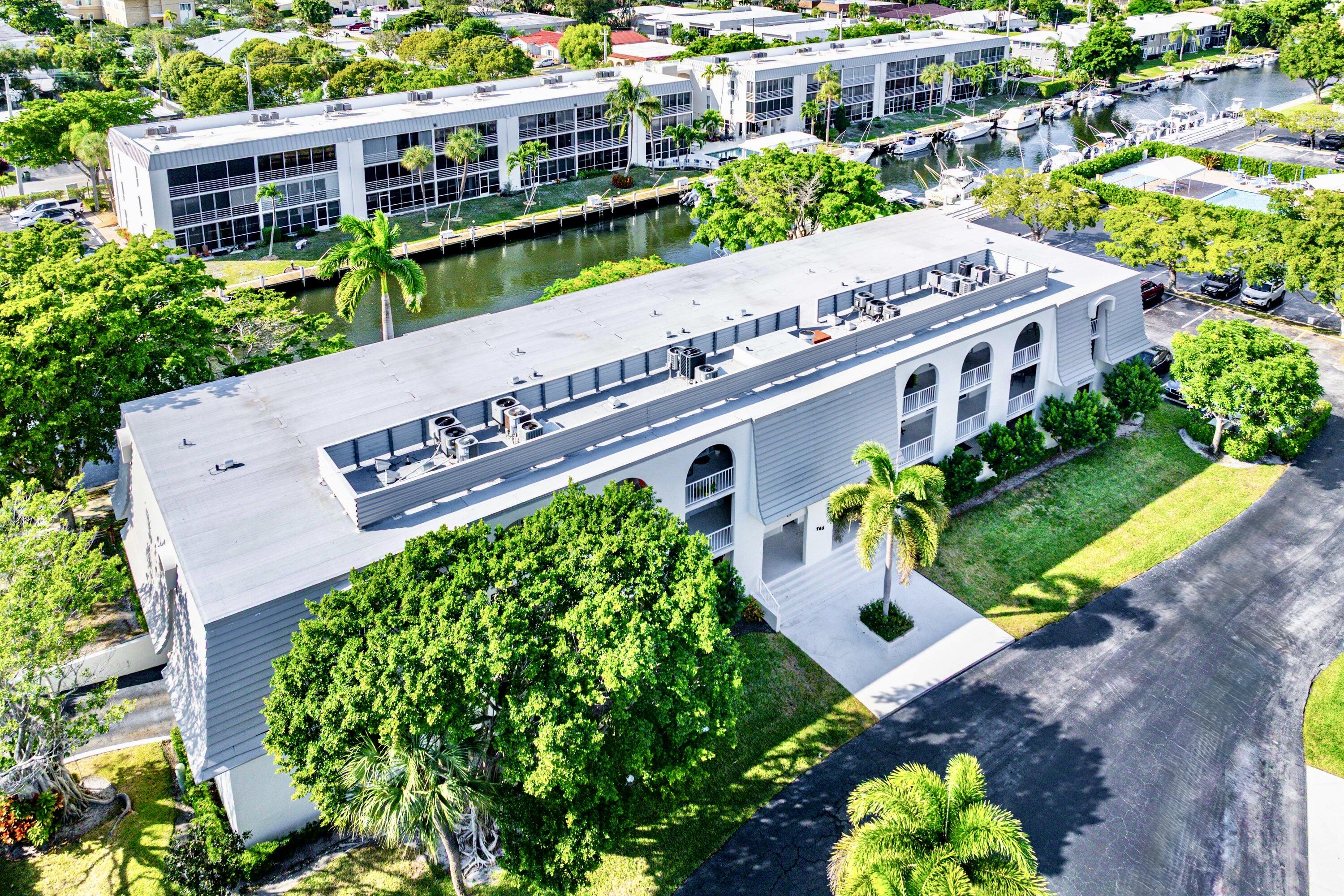 765 Jeffery Street, Unit 1203 Boca Raton, FL 33487 - Photo 29 of 31 a large green building with trees in the background