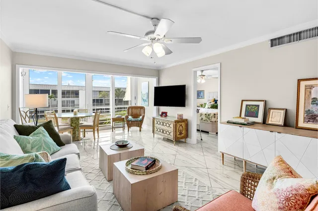 a living room with furniture a flat screen tv and a floor to ceiling window