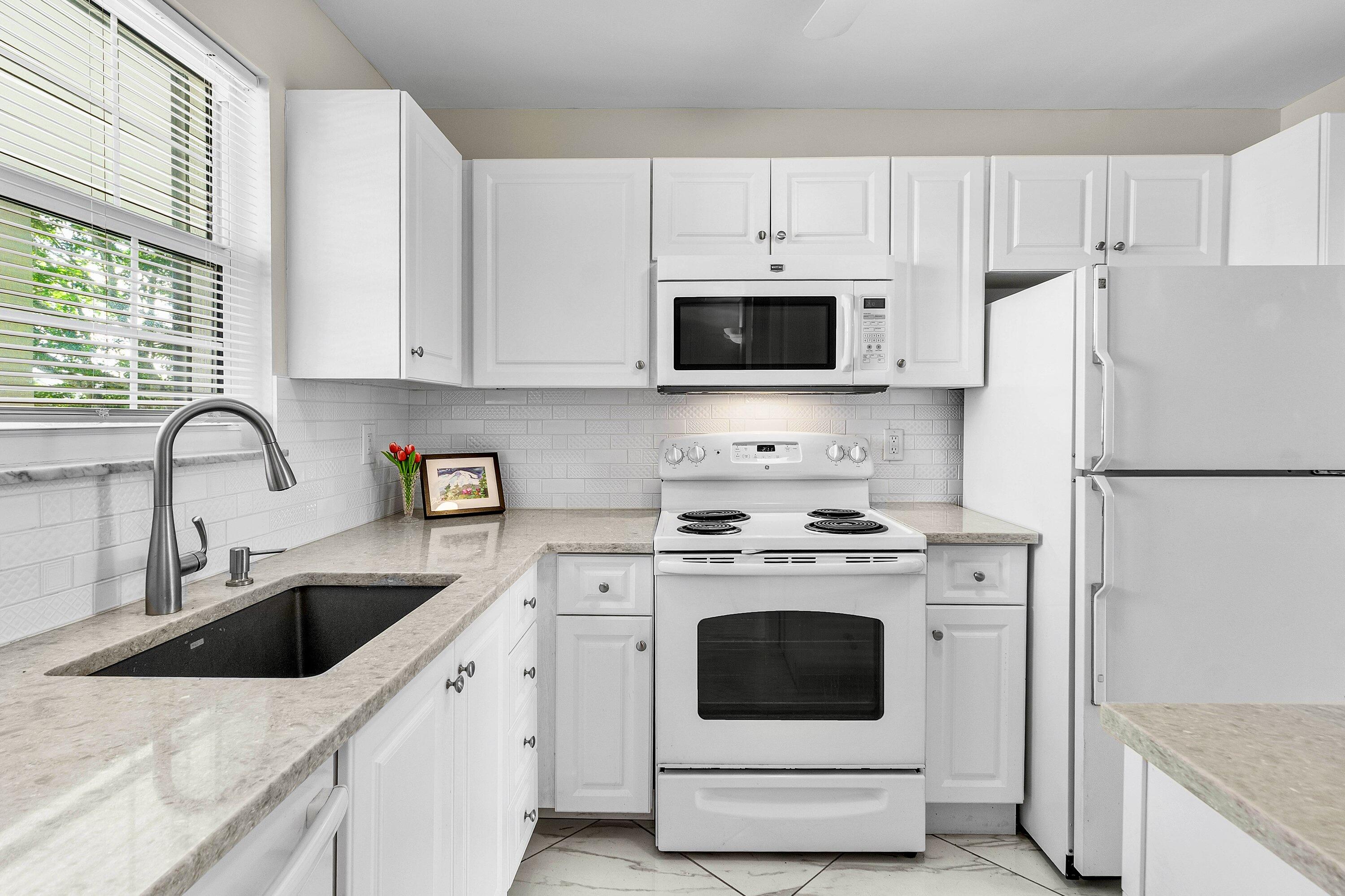 765 Jeffery Street, Unit 1203 Boca Raton, FL 33487 - Photo 8 of 31 a kitchen with white cabinets stainless steel appliances and a sink
