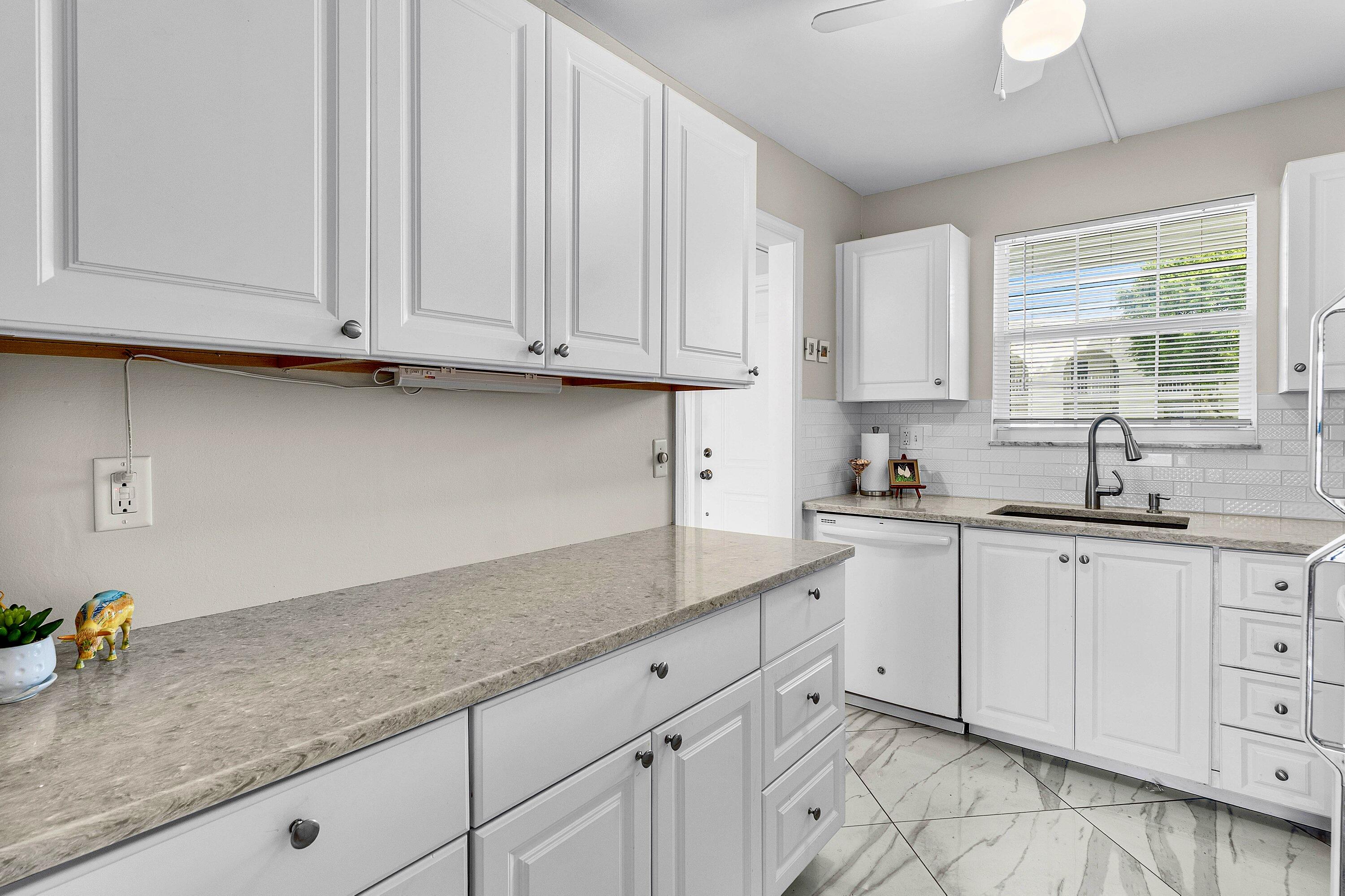765 Jeffery Street, Unit 1203 Boca Raton, FL 33487 - Photo 10 of 31 a kitchen with granite countertop white cabinets and sink