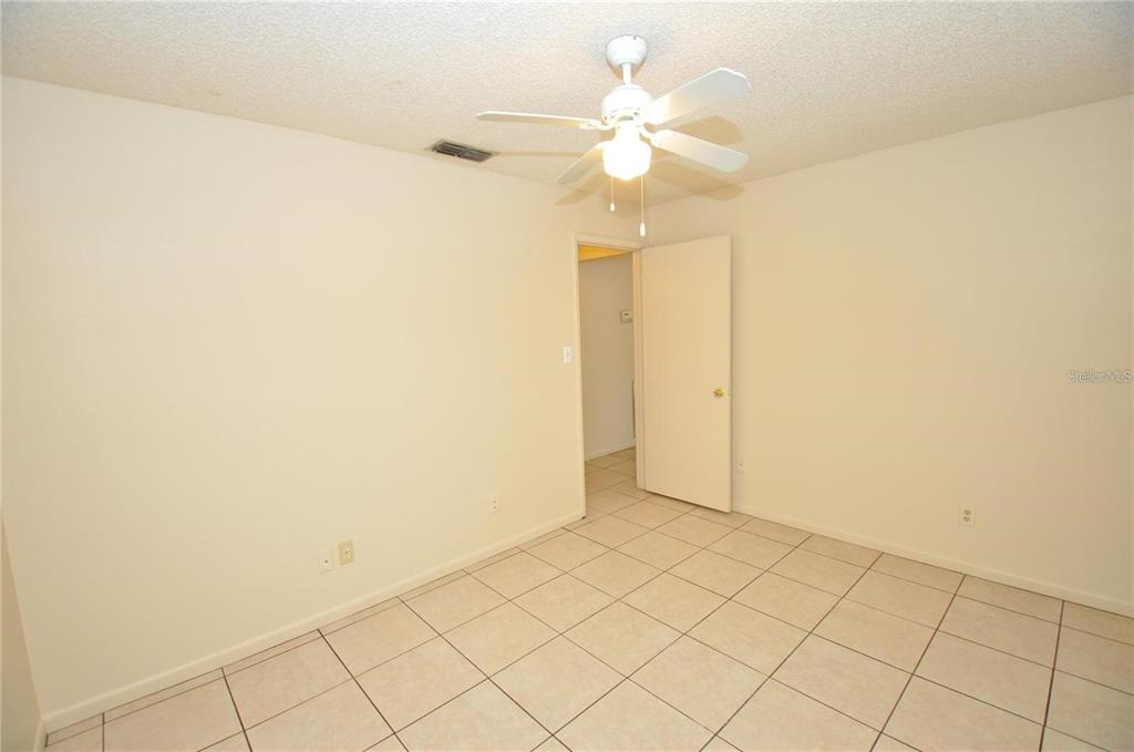 1434 East Fern Road, Unit 1434 Lakeland, FL 33801 - Photo 9 of 13 an empty room with a ceiling fan and a window