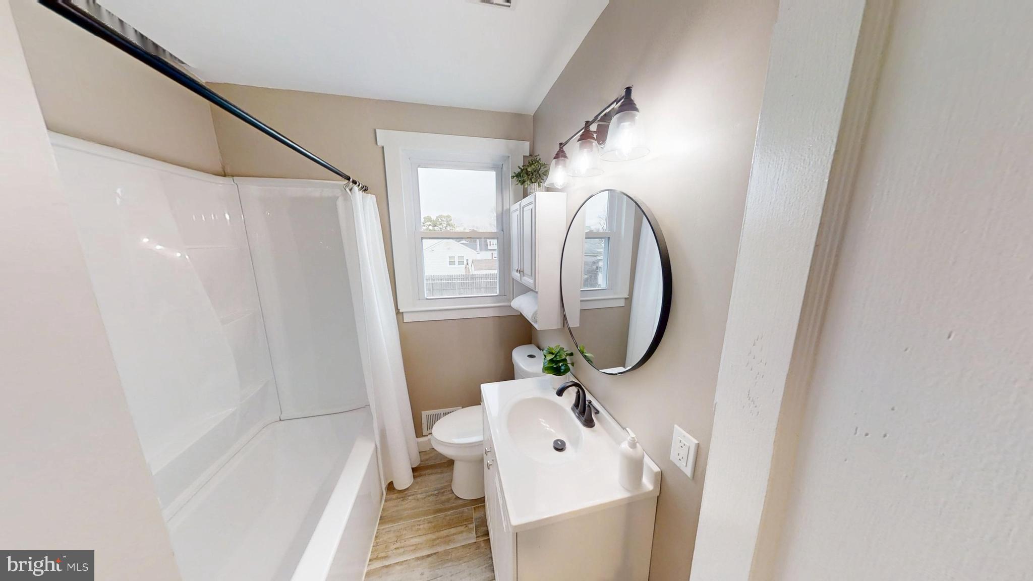 308 Holy Cross Road Baltimore, MD 21225 - Photo 13 of 28 a bathroom with a sink a mirror and a shower
