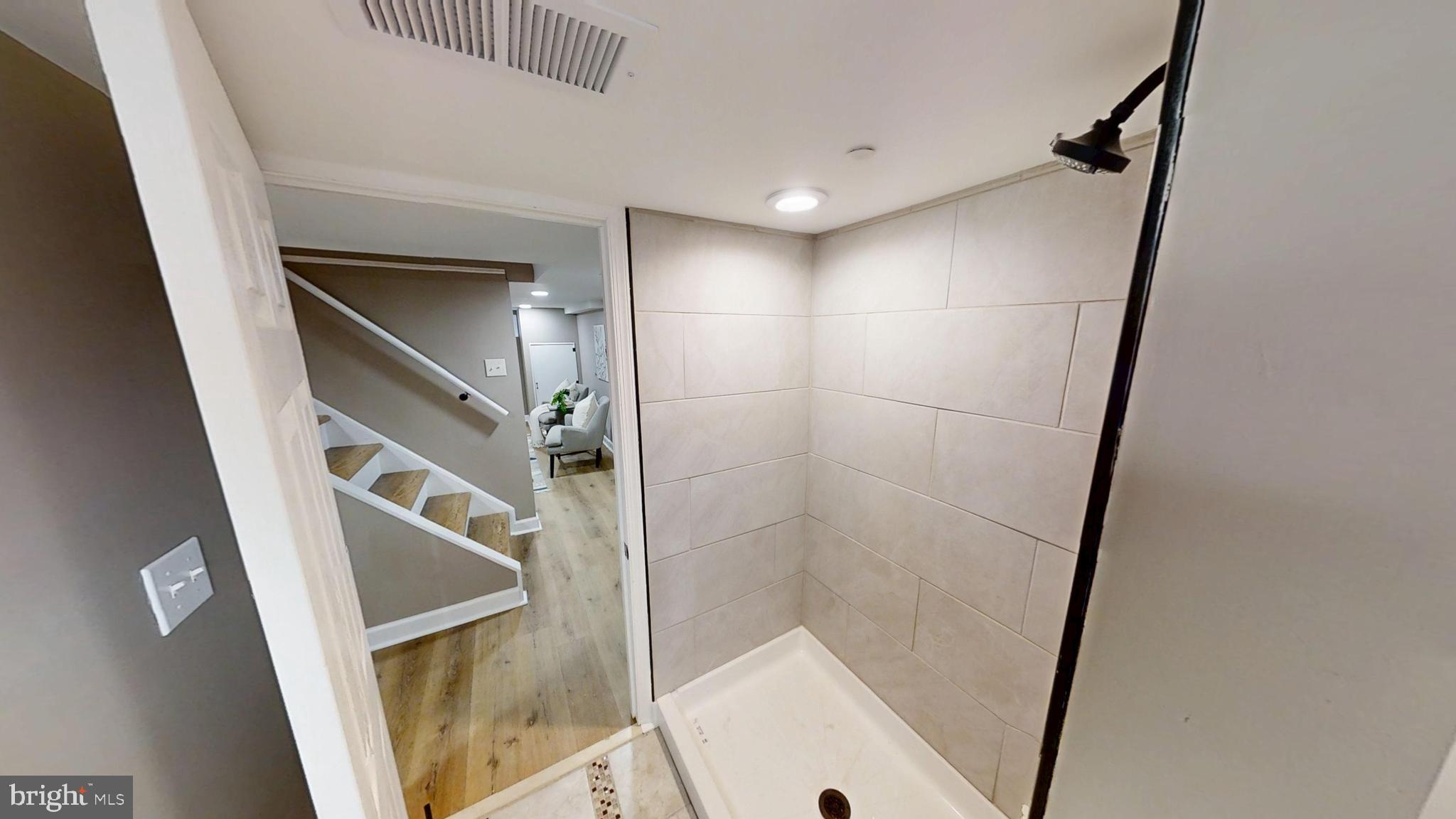 308 Holy Cross Road Baltimore, MD 21225 - Photo 22 of 28 a bathroom with a shower and a mirror