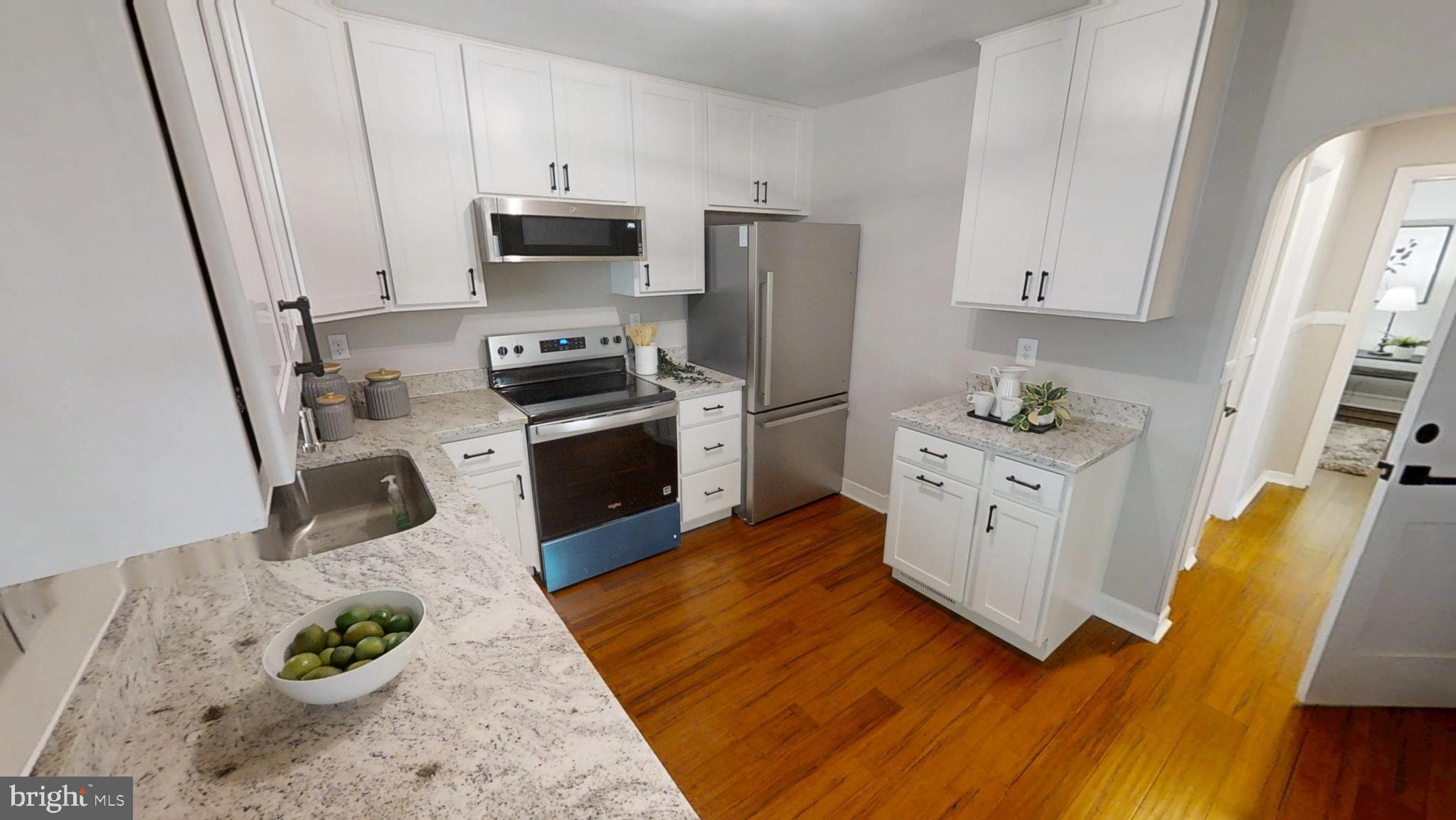 308 Holy Cross Road Baltimore, MD 21225 - Photo 3 of 28 a kitchen with stainless steel appliances a stove a refrigerator a sink a stove and white cabinets