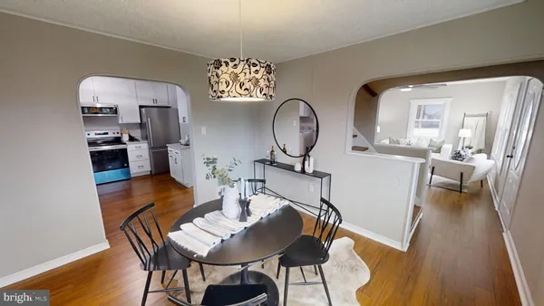a view of a dining room with furniture a chandelier and wooden floor