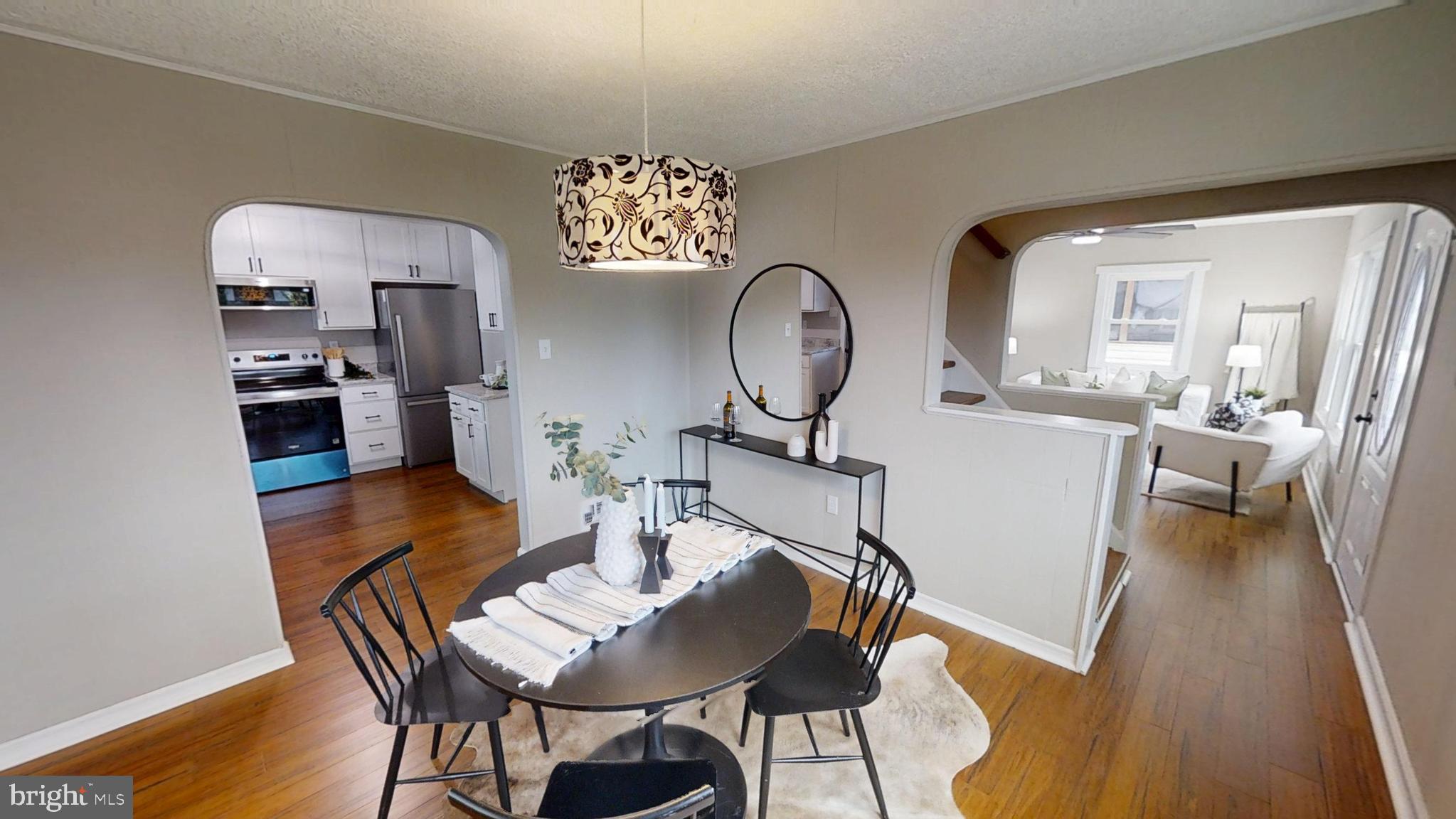308 Holy Cross Road Baltimore, MD 21225 - Photo 5 of 28 a view of a dining room with furniture a chandelier and wooden floor