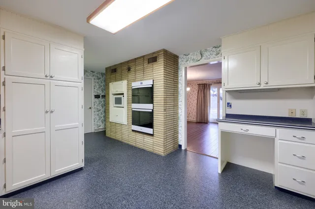 an empty room with wooden floor and fireplace