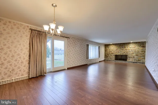 an empty room with wooden floor and fireplace