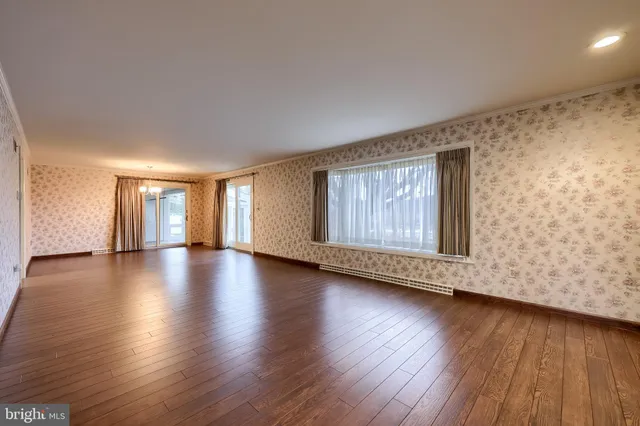 a view of a big room with wooden floor and windows