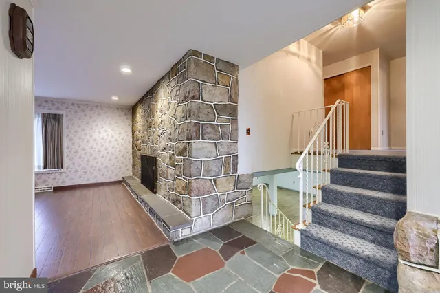 a view of a livingroom with wooden floor and a ceiling fan