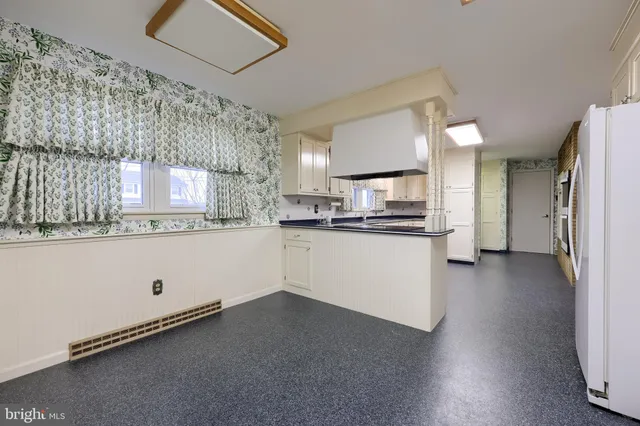 a view of a livingroom with wooden floor a ceiling fan and window