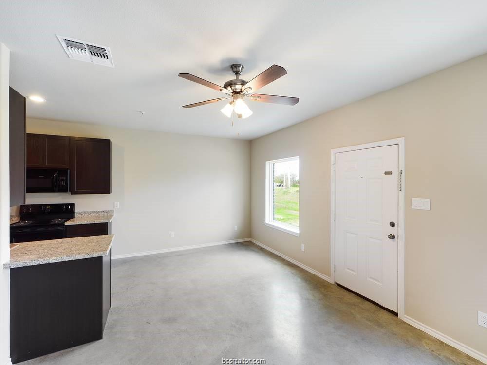 2910 Town Square Avenue, Unit 2111 Bryan, TX 77802 - Photo 3 of 9 a view of a kitchen with a sink a ceiling fan and a wooden floor