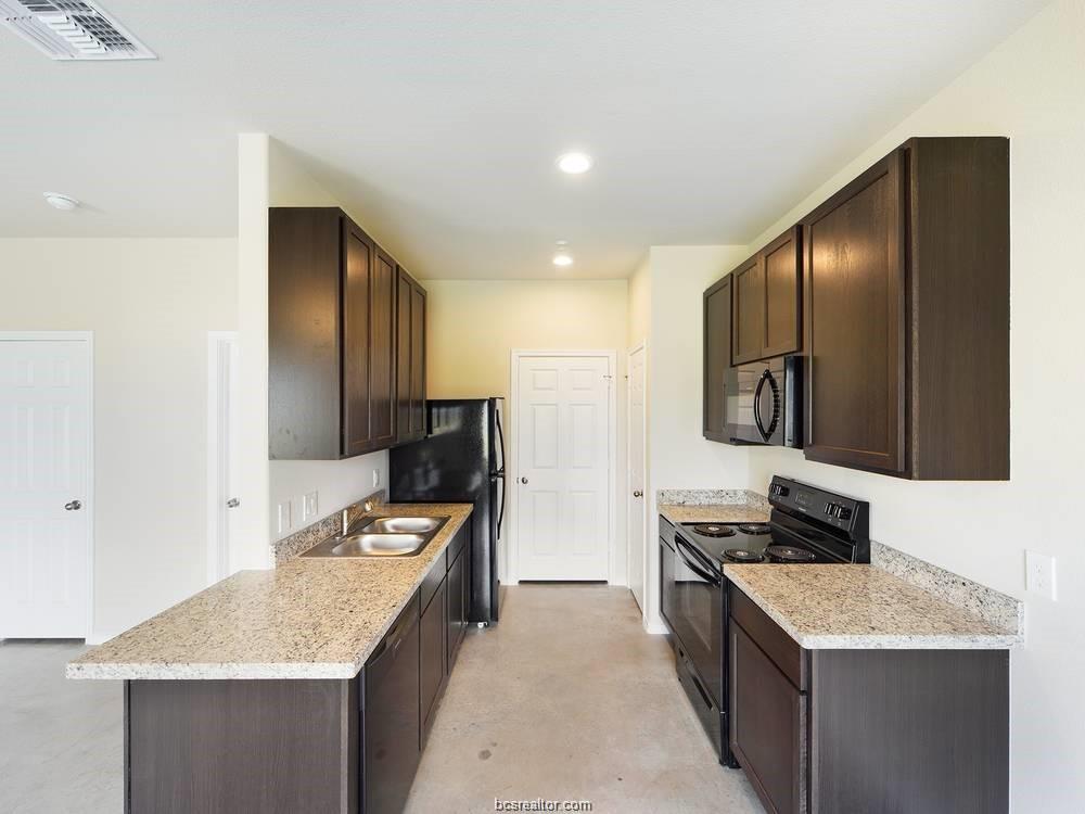 2910 Town Square Avenue, Unit 2111 Bryan, TX 77802 - Photo 4 of 9 a kitchen that has a sink and a stove in it