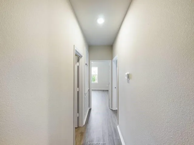 a view of a hallway with wooden floor