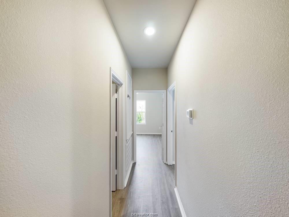 2910 Town Square Avenue, Unit 2111 Bryan, TX 77802 - Photo 6 of 9 a view of a hallway with wooden floor