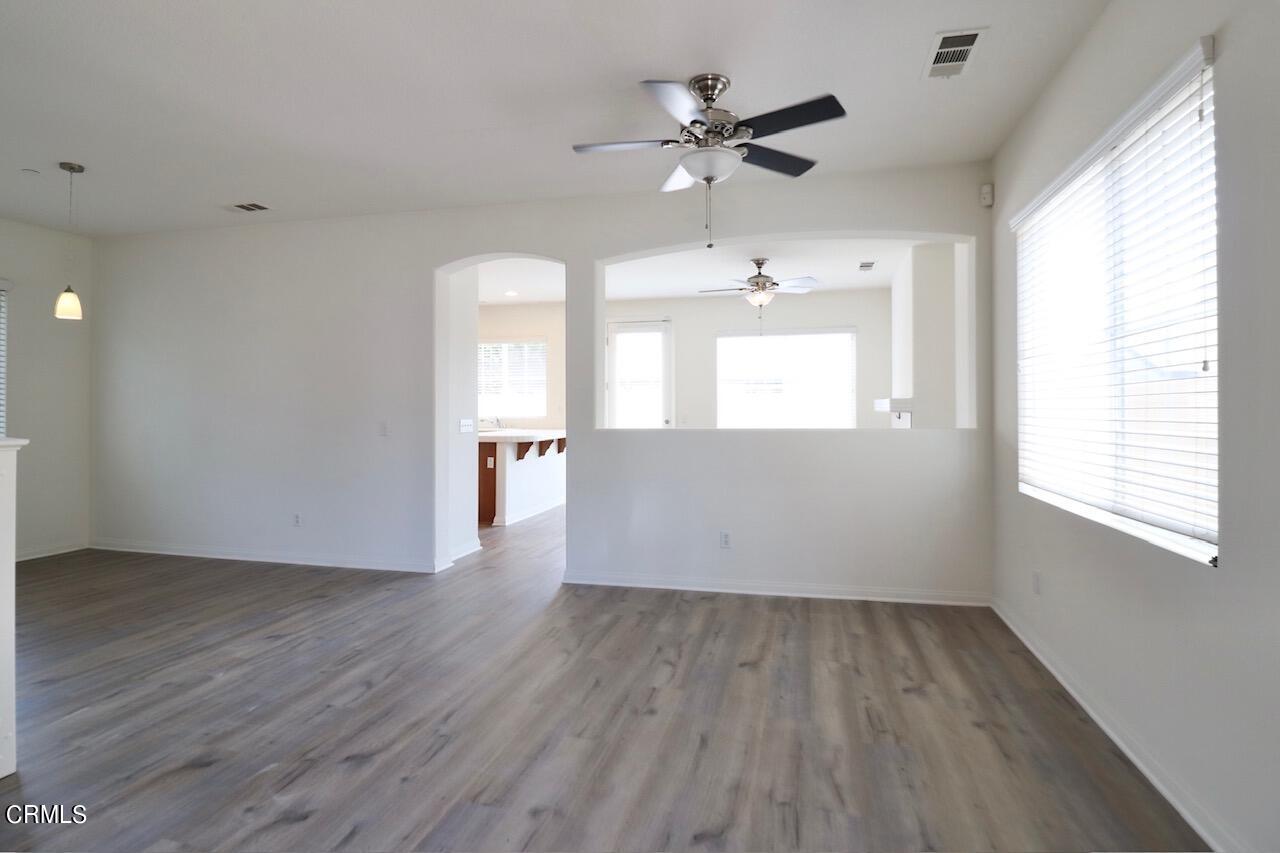 5200 Edgar Street Oxnard, CA 93033 - Photo 3 of 20 an empty room with wooden floor chandelier fan and windows