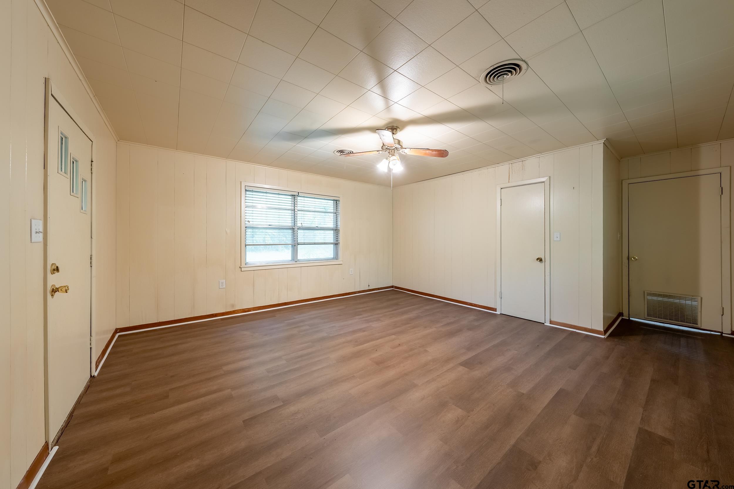 274 West Hill Street Rusk, TX 75785 - Photo 18 of 26 an empty room with wooden floor chandelier fan and windows