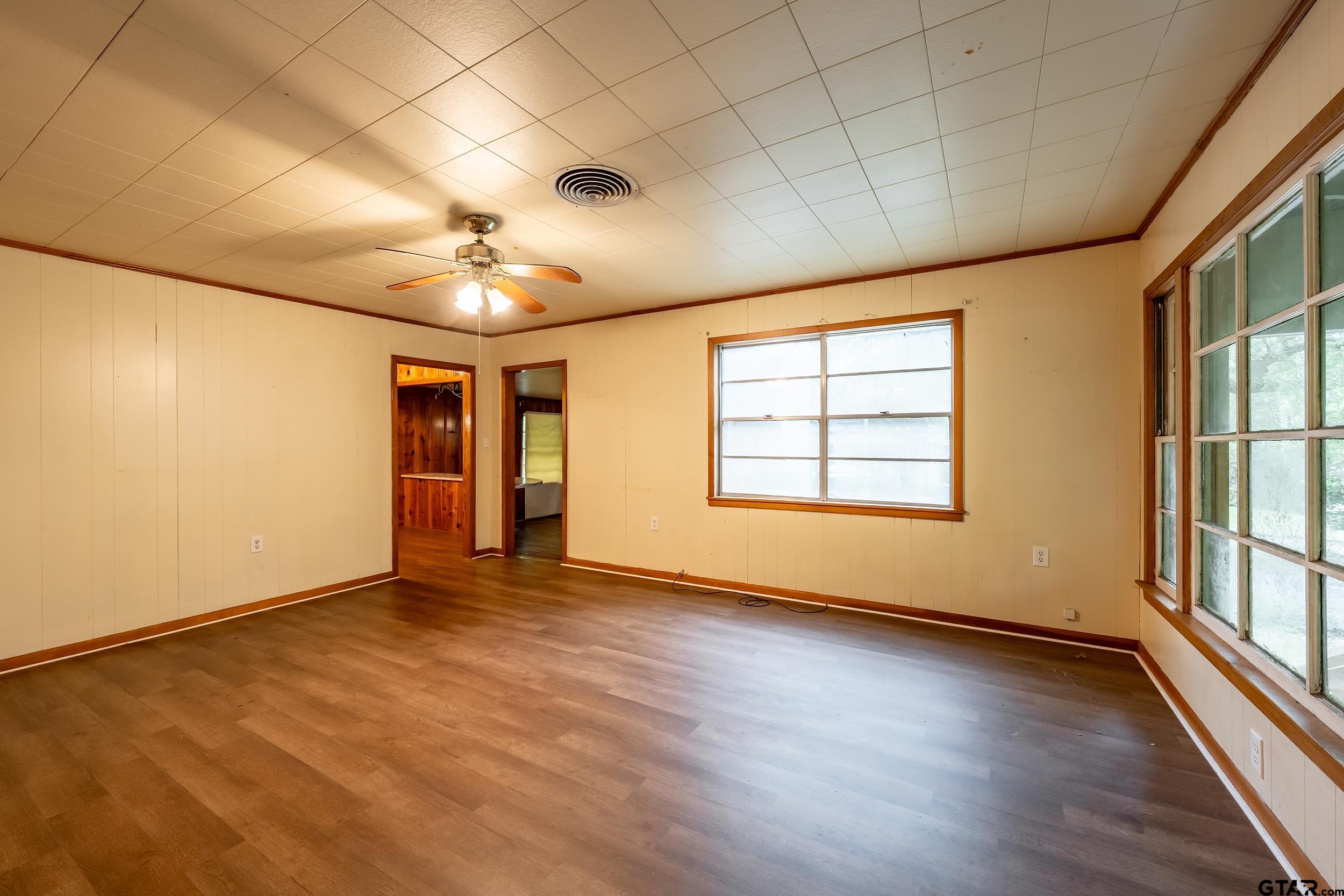 274 West Hill Street Rusk, TX 75785 - Photo 21 of 26 an empty room with wooden floor and windows