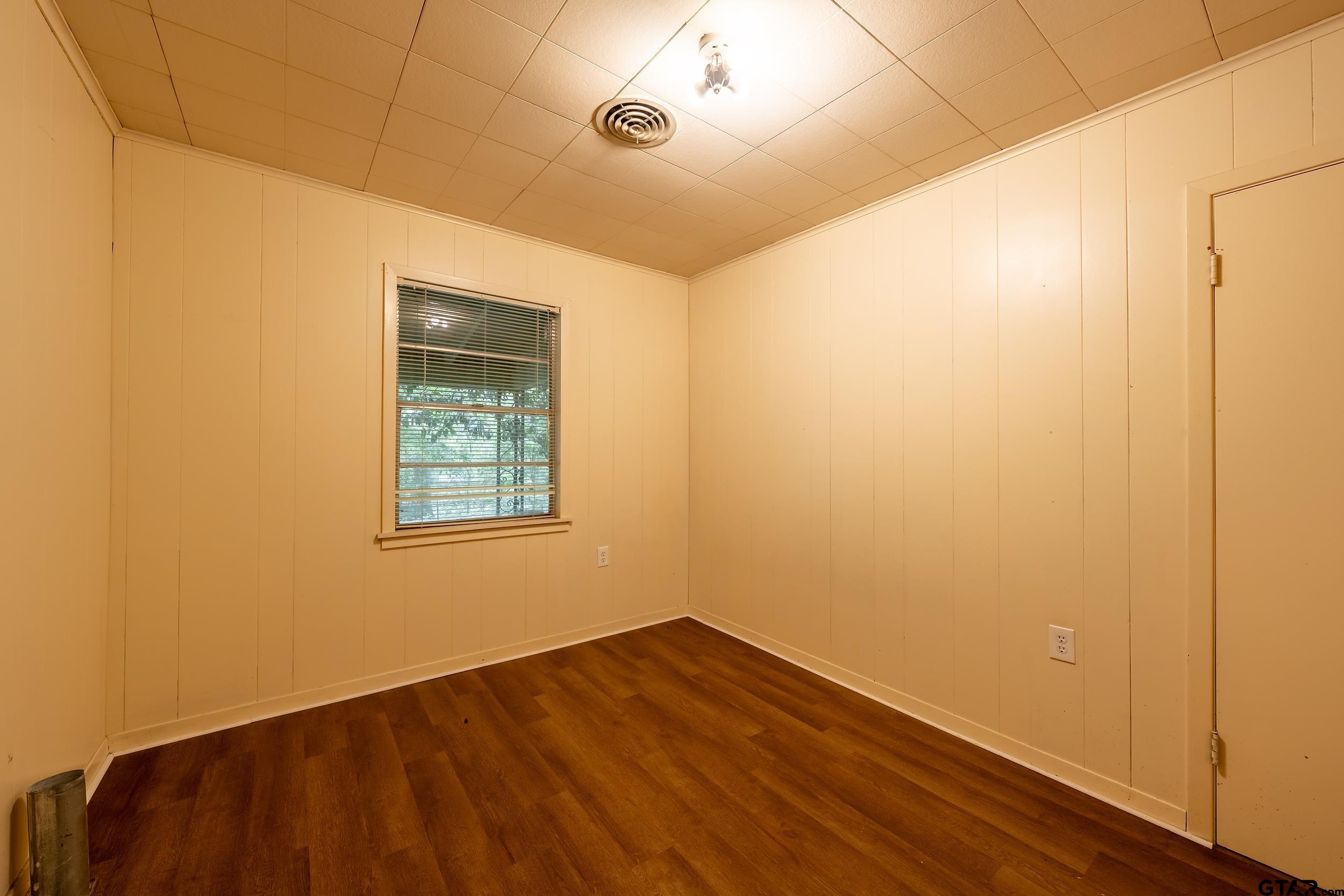 274 West Hill Street Rusk, TX 75785 - Photo 24 of 26 an empty room with wooden floor and windows