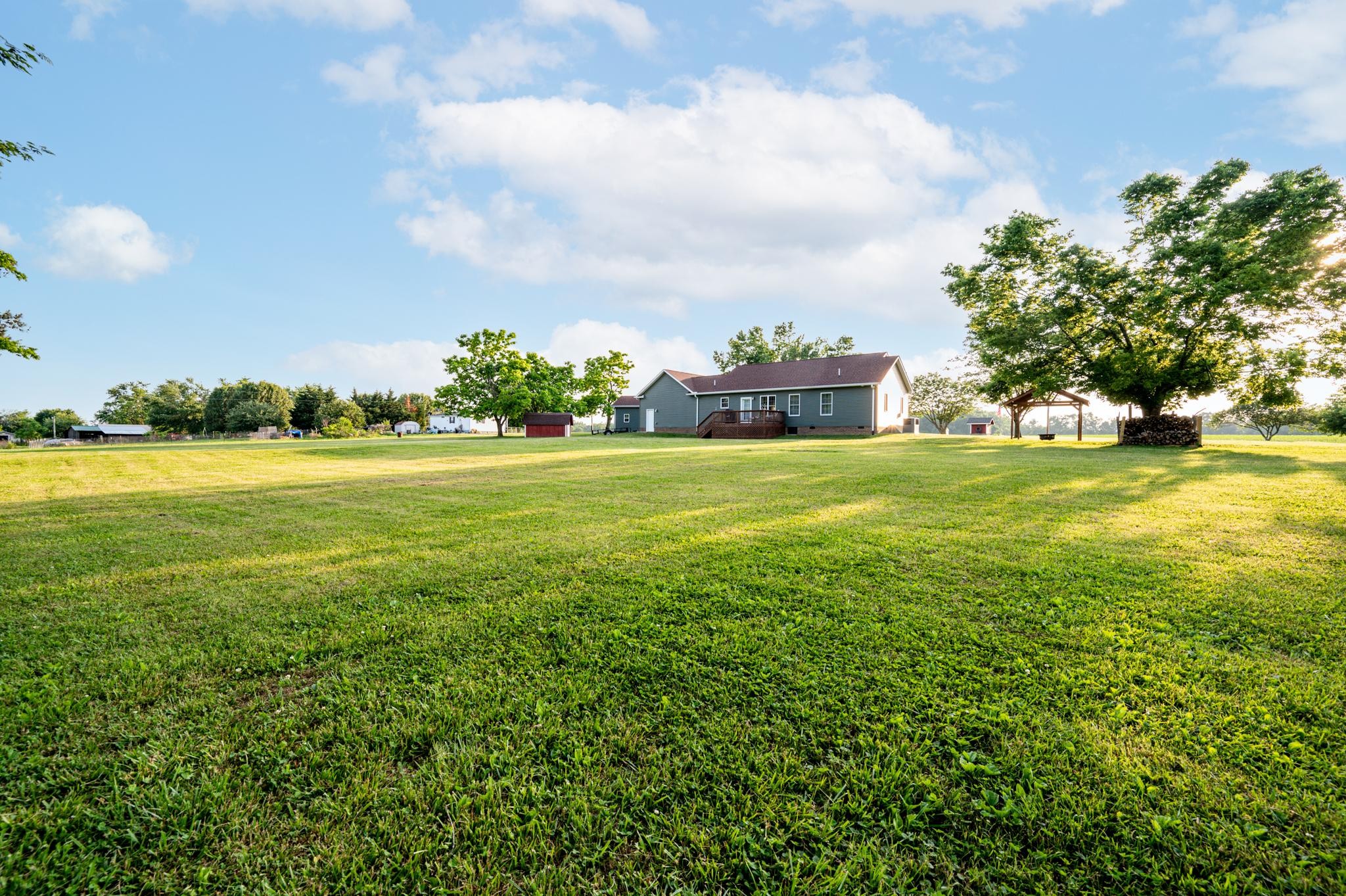 8284 Fredonia Road Manchester, TN 37355 - Photo 18 of 25 a view of a big yard with lawn chairs and large trees