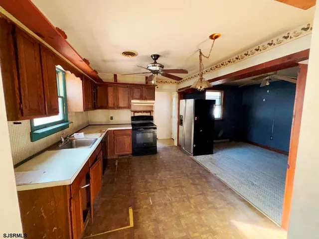 a kitchen with stainless steel appliances granite countertop a refrigerator a sink and a stove