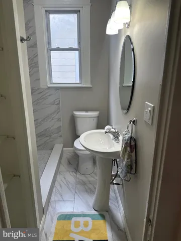a bathroom with a sink mirror vanity and toilet