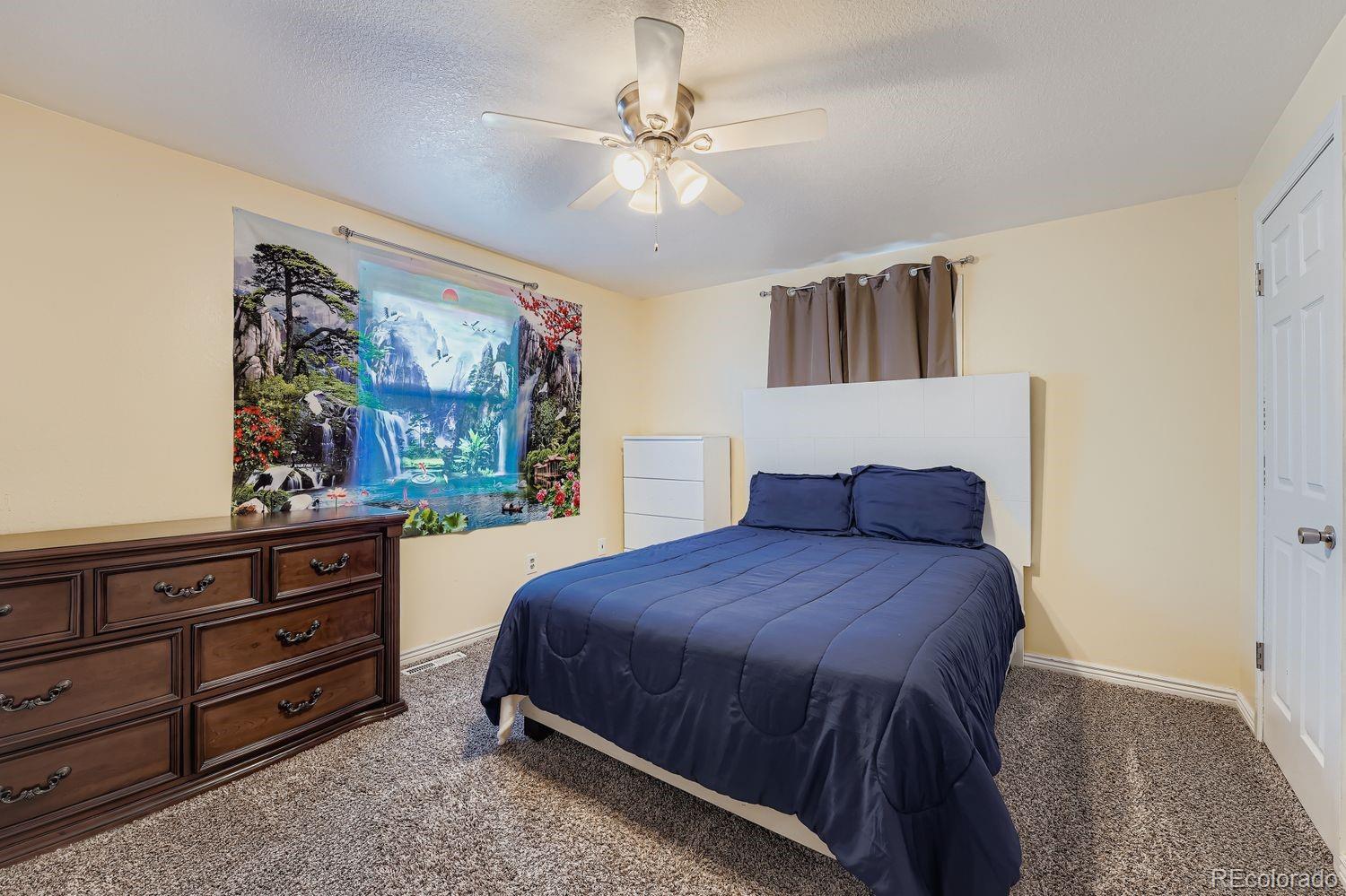 361 East Thomas Avenue Byers, CO 80103 - Photo 13 of 28 a bedroom with a bed and a dresser
