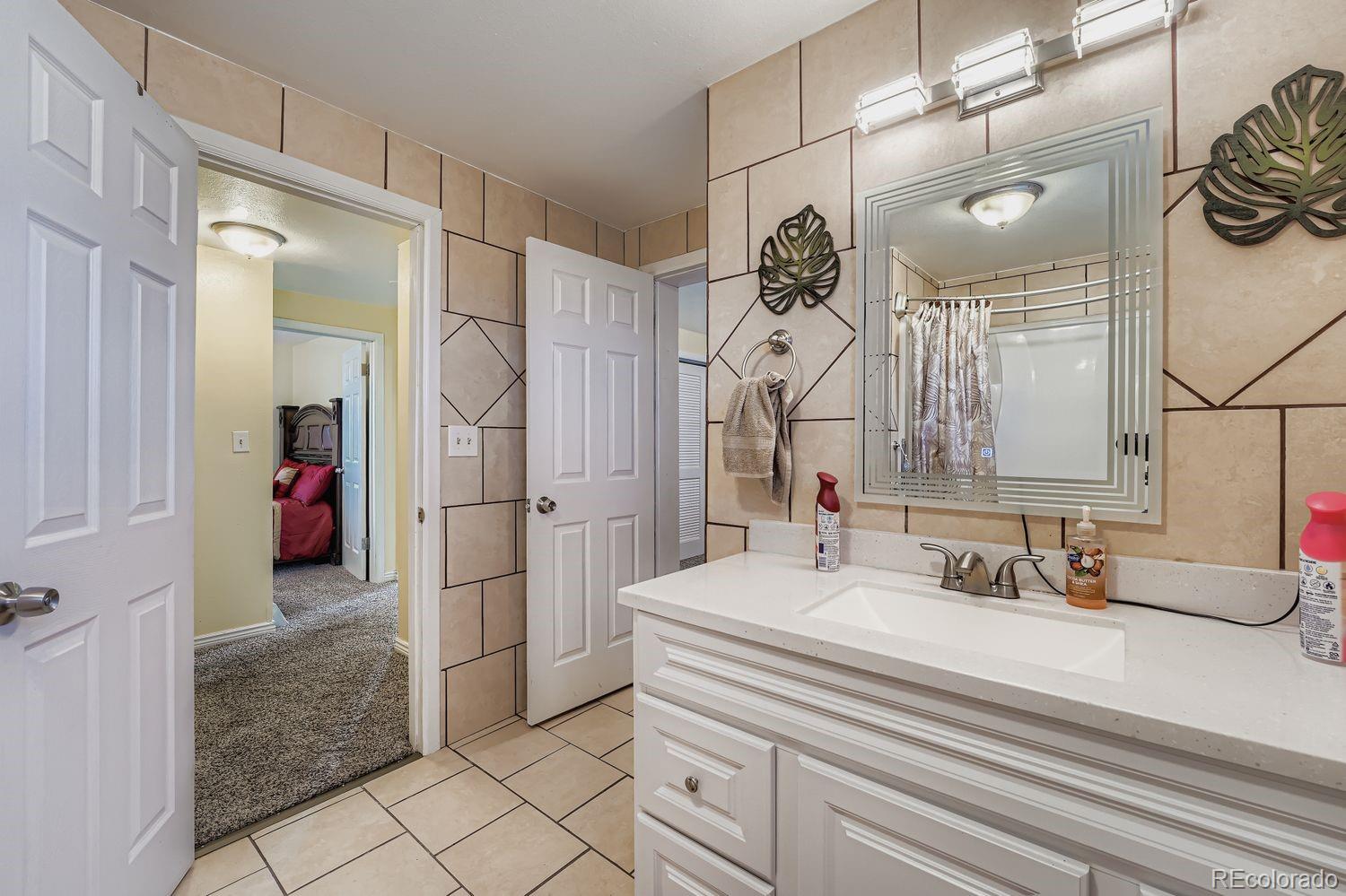 361 East Thomas Avenue Byers, CO 80103 - Photo 15 of 28 a bathroom with a sink and a mirror