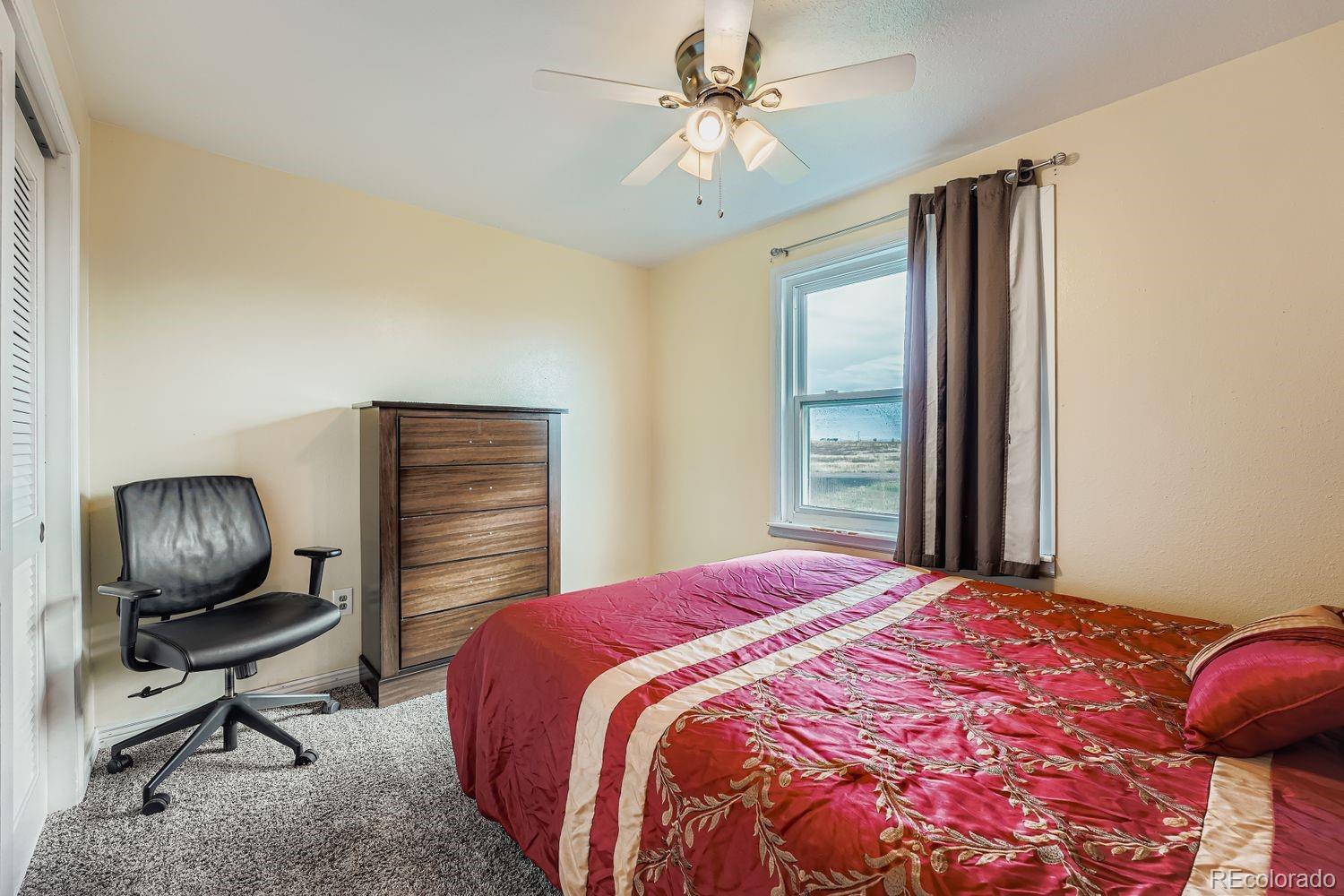 361 East Thomas Avenue Byers, CO 80103 - Photo 17 of 28 a bedroom with a bed and a chandelier